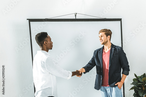 side view of multicultural businessmen shaking hands during business seminar