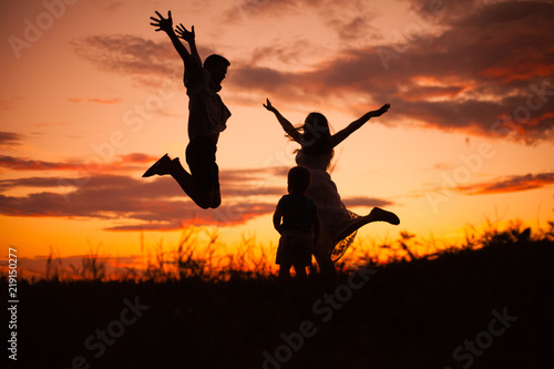 family, silhouettes of mom and dad on a background of beautiful sky, sunset, family at sunset