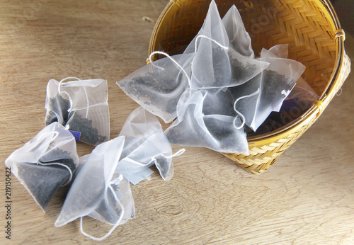 bags of elite tea in silk fabric packing on a wooden background