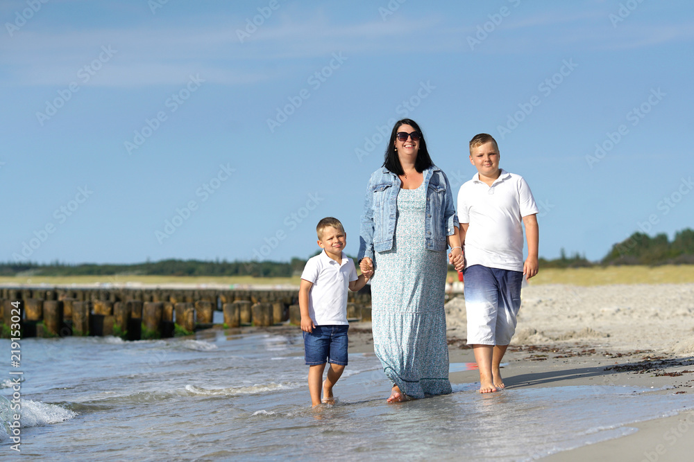 Kinder mit ihrer schwangeren Mutter am Strand Kinder mit ihrer schwangeren Mutter am Strand