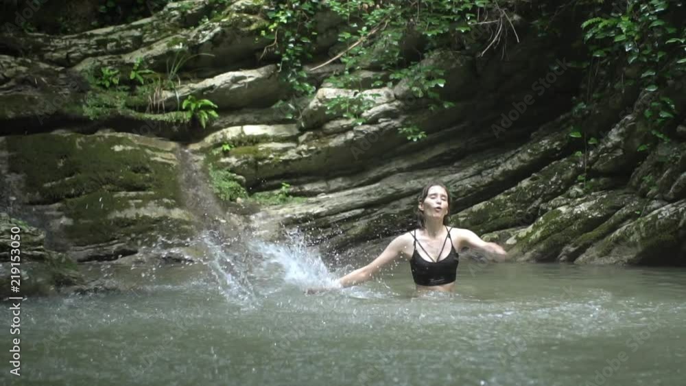 Slow Motion Young happy woman splashes on water by hands Slow Motion Young happy woman splashes on water by hands