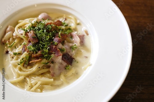 Italian cuisine, Spaghetti Cabana or Spaghetti White Sauce on white dish at restaurant, top view