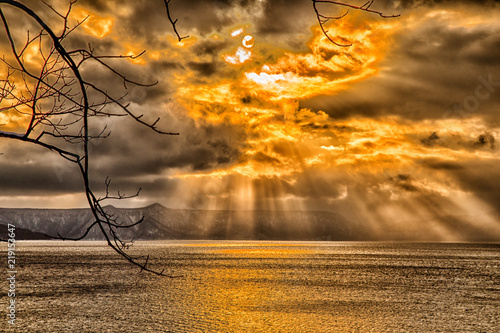 sky breakthrough over the sea with dark cloud and orange sun light, very amazing sky in the winter photo