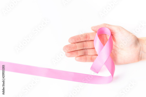 Pink ribbon symbol for breast cancer awareness concept in woman hand over white background with copy space for text, logo, or wordings insertion or decoration