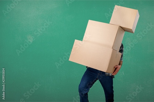 Delivery man carrying stacked boxes