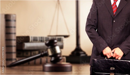 Judge man in black suit holding blue notebook