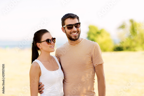 people and relationships concept - happy couple in sunglasses outdoors in summer