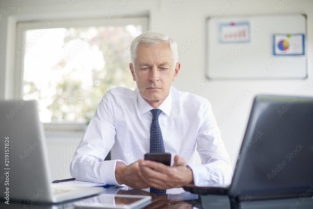 Businessman holding mobile phone in his hand Businessman holding mobile phone in his hand