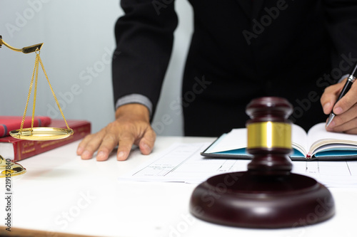 Business lawyer writing hard at office desk workplace with paper and documents.concept
