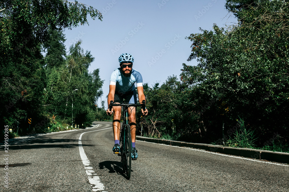 Obraz premium A man riding a bicycle on a mountain road