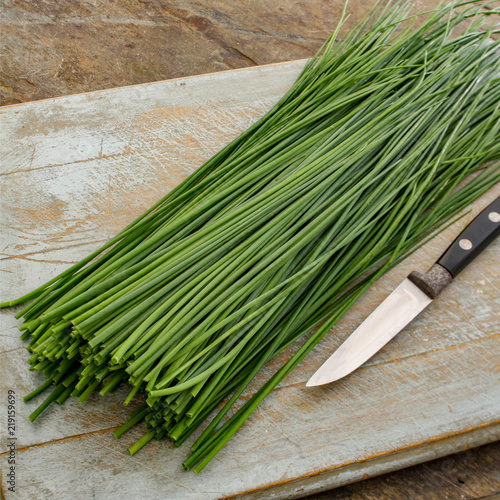 slicing fresh chives on chopping board
