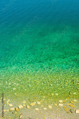 Fototapeta Naklejka Na Ścianę i Meble -  Aerial abstract shot of a coastline color gradient from yellow to blue deeper sea