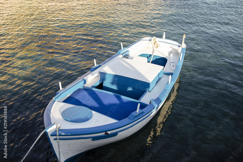 White and blue moored boat on a Greece island. White and blue moored boat on a Greece island.