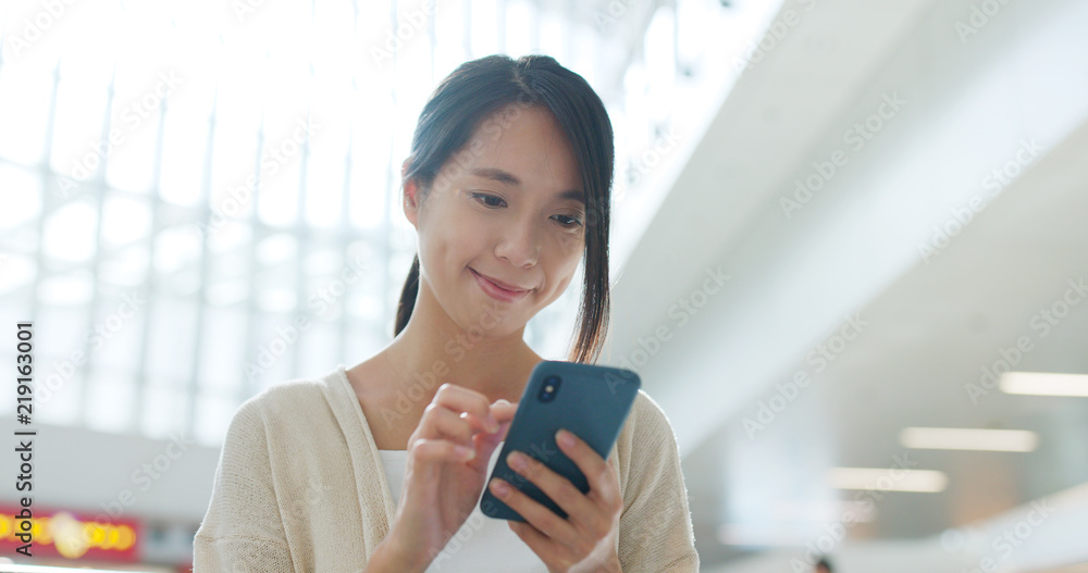 Woman use of mobile phone inside airport Woman use of mobile phone inside airport