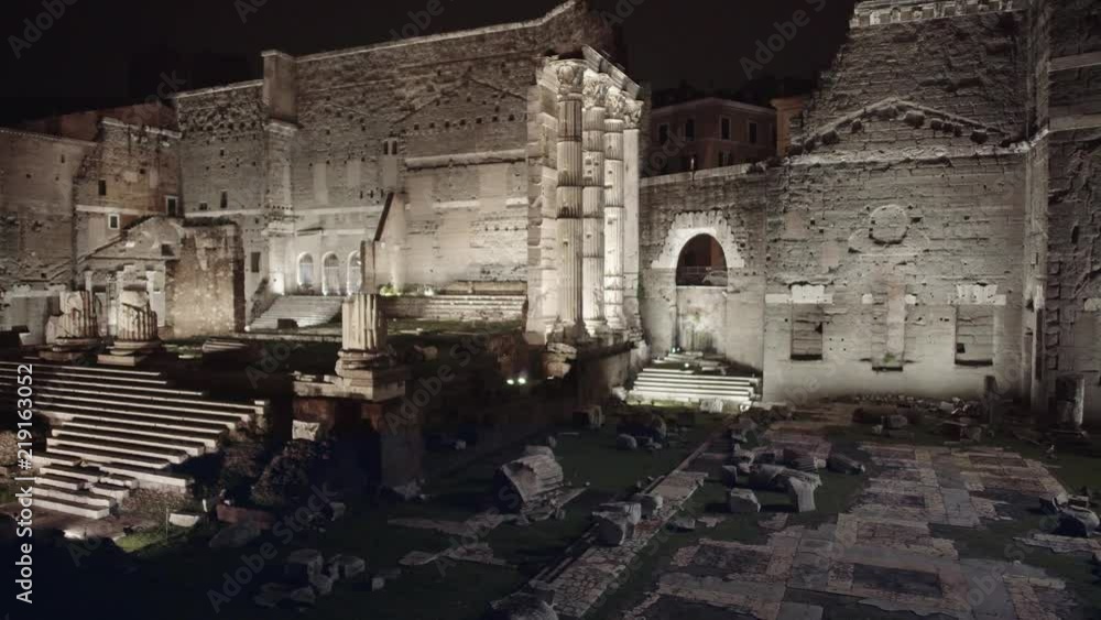 Roman Colosseum on winter night. Ruins near the famous historical building. Columns. Left to right pan real time establishing shot Roman Colosseum on winter night. Ruins near the famous historical building. Columns. Left to right pan real time establishing shot