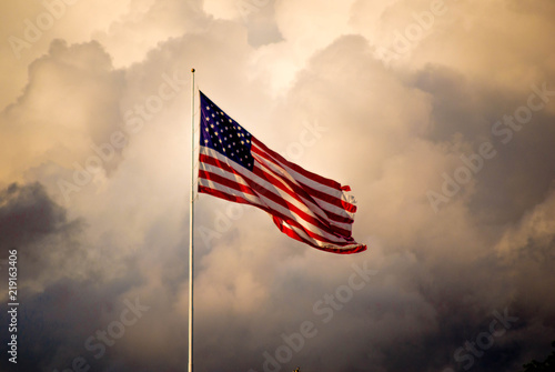 The American flag flies high as a storm approaches photo