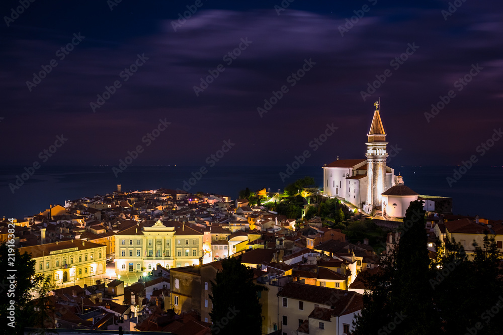 Night cityscape of city of Piran, Slovenia with big dominant St. George's Parish Church and main square