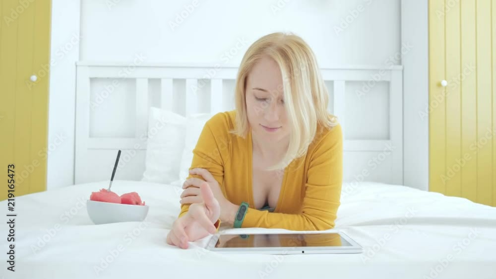 Attractive female lying next to the digital tablet PC and suffing the web Attractive female lying next to the digital tablet PC and suffing the web