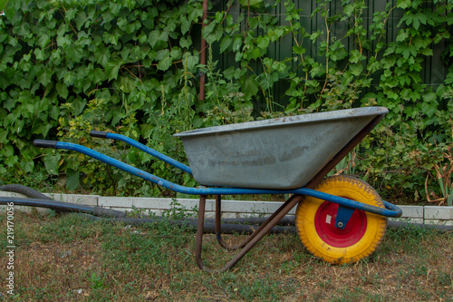 Fotografia A metal wheelbarrow with a yellow wheel for home and garden