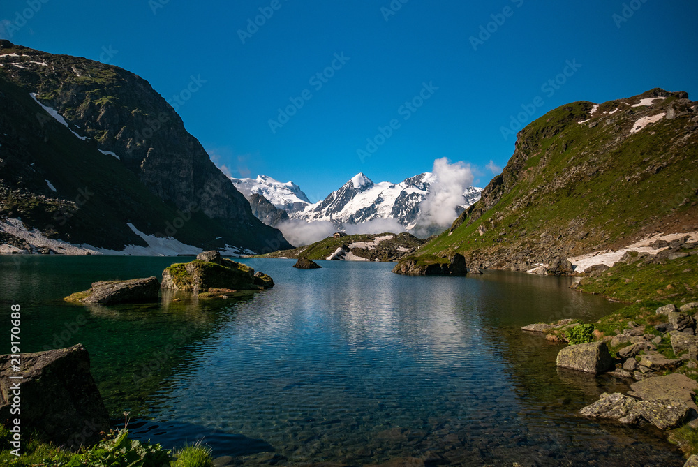 Obraz premium Swiss alps water reflection in Lac de Louvie - mountain lake above Val de Bagnes valley, Switzerland.