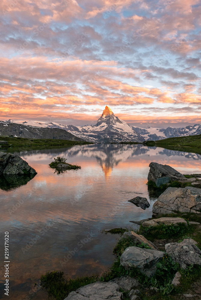 Obraz premium Morning shot of the golden Matterhorn (Monte Cervino, Mont Cervin) pyramid and blue Stellisee lake. Sunrise view of majestic mountain landscape in Switzerland.