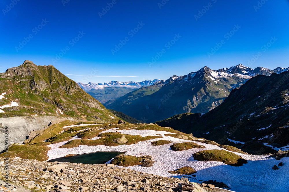 Obraz premium Scenic view of beautiful landscape in Swiss Alps. Fresh green meadows and snow-capped mountain tops in the background in springtime, Switzerland.