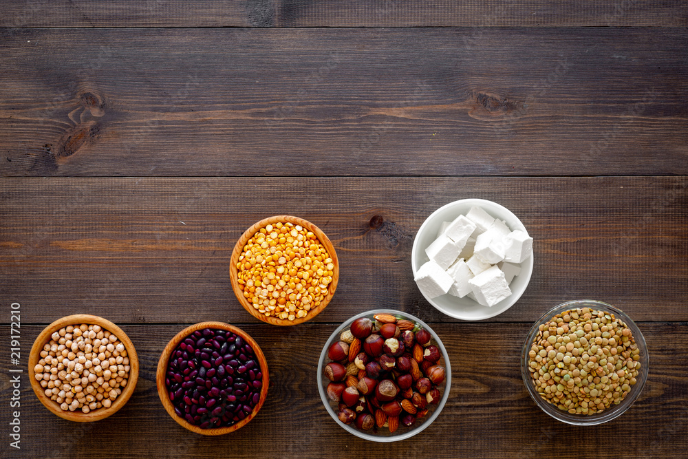 Vegan protein source. Legumes, nuts, cheese. Raw beans, chickpeas, lentil, almond, hazelnut on dark wooden background top view copy space Vegan protein source. Legumes, nuts, cheese. Raw beans, chickpeas, lentil, almond, hazelnut on dark wooden background top view copy space