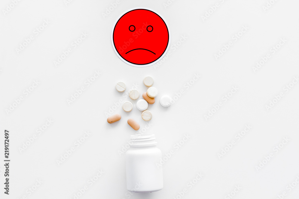 Illness. Drug intake. Pills falling out of jar near sad face emoji on white  background top view copy space Photos | Adobe Stock