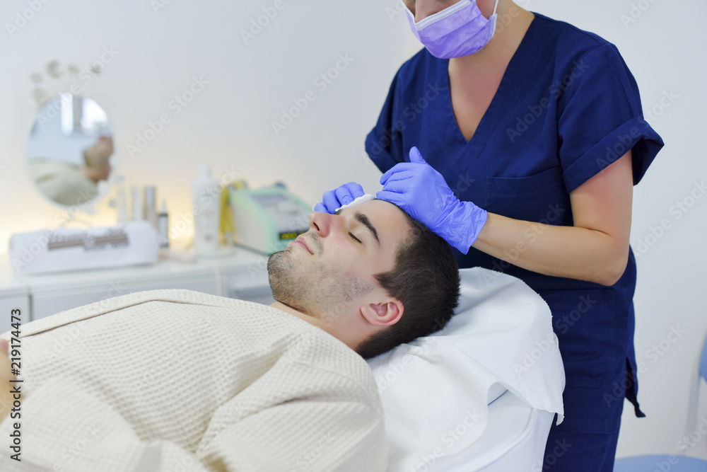 Young man on face treatment Young man on face treatment