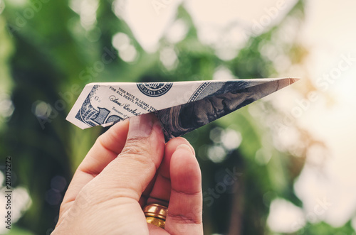 Obraz na płótnie Business grow concept Hand holding rocket money paper airplay folding with dolla