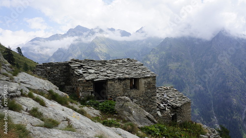 Ruina chaty z kamiennego dachu na górskim stoku alpejskim