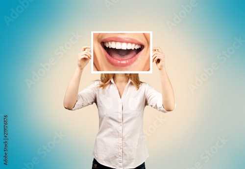 Woman holding picture with big smile. concept photo over dark