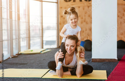 A small daughter sits at her mother's back