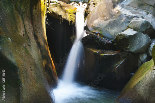 Small tranquil waterfall among the rocks of the mountain creek