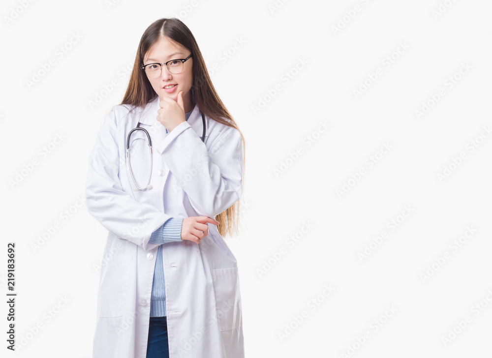 Young Chinese doctor woman over isolated background looking confident at the camera with smile with crossed arms and hand raised on chin. Thinking positive. Young Chinese doctor woman over isolated background looking confident at the camera with smile with crossed arms and hand raised on chin. Thinking positive.