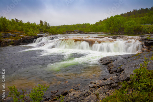 Small waterfall next to Valnesforsen fall in rainny day in Norway