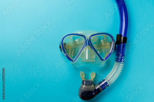 Diving equipment. Snorkeling mask and tube on blue background. Colorful background. Top view. Copy space. Close up