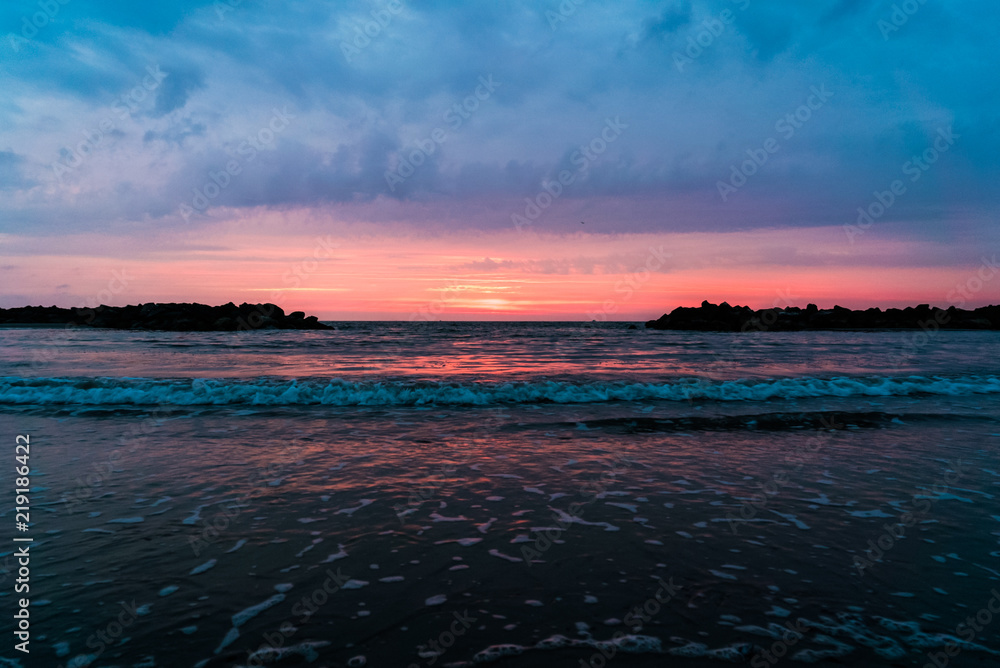 Morgendämmerung am Meer, der Horizont flankiert von zwei Felsen