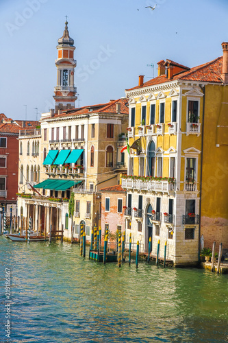 View on the historic architecture and the canal between the ancient buildings in Venice, Italy on a sunny day.