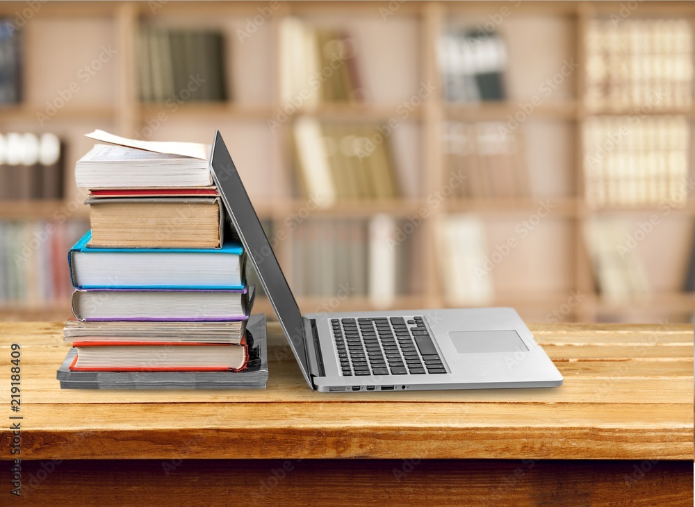 Stack of books with laptop on table Stack of books with laptop on table