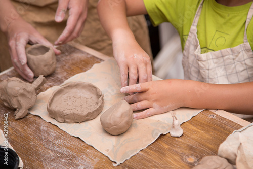 Pottery workshop for kids, raw clay, sculpting tools, glazing and painting clay pots