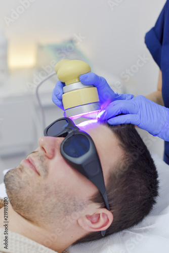 Young man on face treatment photo