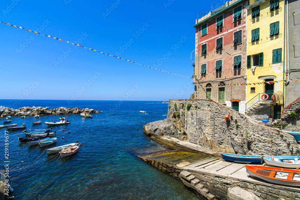 View on the beautiful colourful houses and the floating fishing boats in the harbour of Cinque Terre, Italy.
