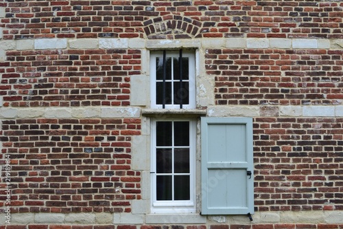 Closeup photograph of a window in a historical brick-and-limestone building. Taken at Park Abbey, Leuven, Belgium, Europe.