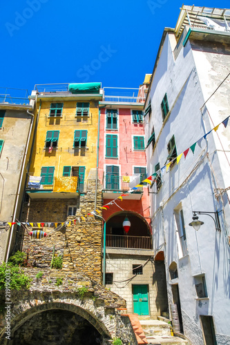 View on the beautiful colourful houses with clothes drying in the sunny daylight in Cique Terre, Italy. photo