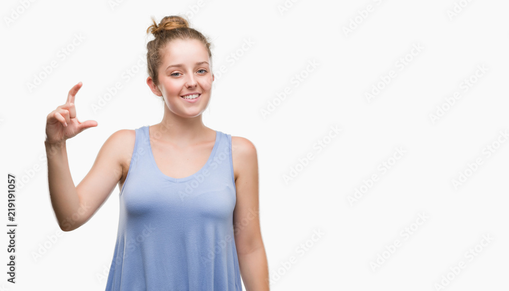 Young blonde woman smiling and confident gesturing with hand doing size sign with fingers while looking and the camera. Measure concept. Young blonde woman smiling and confident gesturing with hand doing size sign with fingers while looking and the camera. Measure concept.