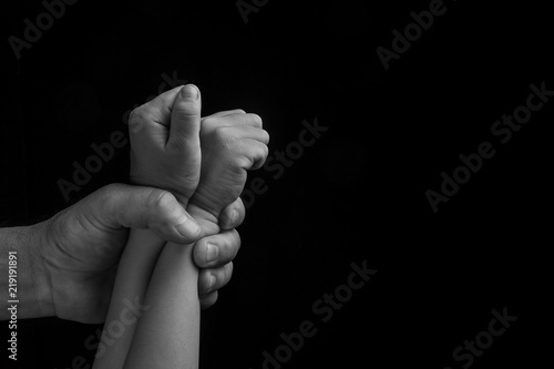 Man hand holding tight children hands, Human trafficking, End to violence against children.