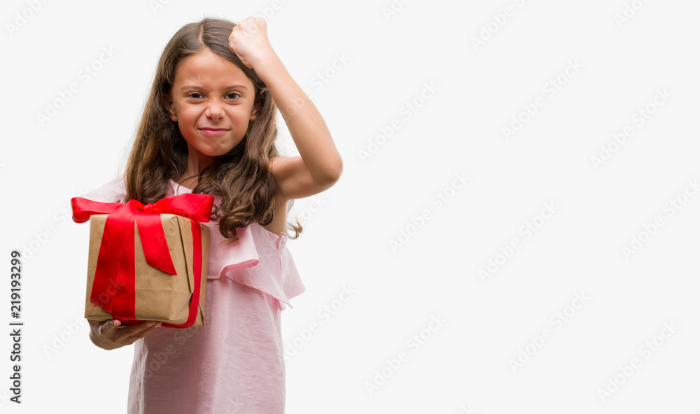 Brunette hispanic girl holding a gift annoyed and frustrated shouting with anger, crazy and yelling with raised hand, anger concept Brunette hispanic girl holding a gift annoyed and frustrated shouting with anger, crazy and yelling with raised hand, anger concept