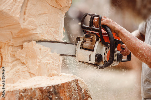 Close-up of woodcutter lumberjack is man chainsaw tree.