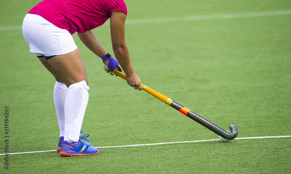 Obraz premium Young hockey player woman with ball in attack playing field hockey game